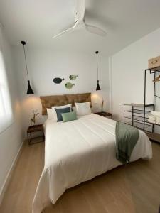 トロクス・コスタにあるApartamentos el Olivoの2つのライトが付いた白い寝室に大きな白いベッド