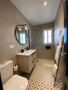 トロクス・コスタにあるApartamentos el Olivoの洗面台、トイレ、鏡のあるバスルーム