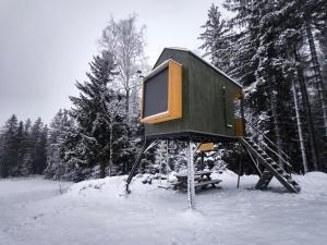 a tree house sitting in the snow in the woods at Posed v lese in Jablonec nad Nisou