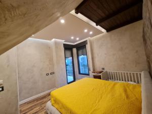 a bedroom with a yellow bed in a room with windows at Lavender Beach House in Draç +86 photos