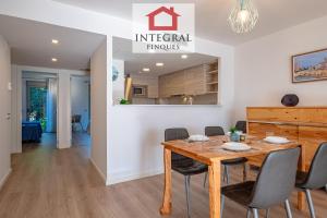 ein Esszimmer mit einem Holztisch und Stühlen in der Unterkunft El Coralí Apartament Palamós in Palamós
