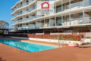 ein Hotel mit einem Swimmingpool vor einem Gebäude in der Unterkunft El Coralí Apartament Palamós in Palamós