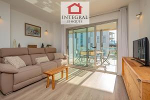 ein Wohnzimmer mit Sofa und Fernseher in der Unterkunft El Coralí Apartament Palamós in Palamós