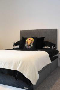 a bedroom with a large bed with a gray headboard at Thomson Haven in Carlisle
