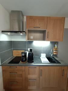 eine Küche mit Holzschränken und einem Herd mit Backofen in der Unterkunft Cozy apartment in Albiez-Montrond near the slopes in Albiez-Montrond