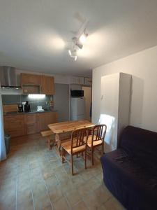 eine Küche mit einem Holztisch und Stühlen darin in der Unterkunft Cozy apartment in Albiez-Montrond near the slopes in Albiez-Montrond
