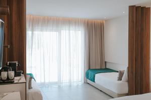 a hotel room with a bed and a large window at Atlantica Sungarden Park in Ayia Napa