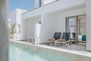 a swimming pool with two chairs and a table at Atlantica Sungarden Park in Ayia Napa