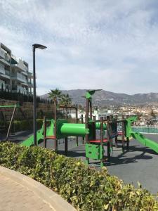 a playground with a green slide in a park at De Droomhacienda in Fuengirola