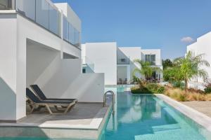 a swimming pool with a chair next to a building at Atlantica Sungarden Park in Ayia Napa
