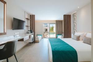a hotel room with a large bed and a desk at Atlantica Sungarden Park in Ayia Napa