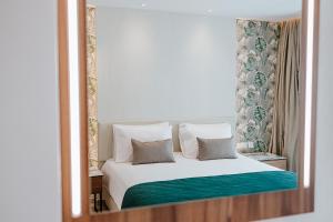 a reflection of a bedroom with a bed in a mirror at Atlantica Sungarden Park in Ayia Napa
