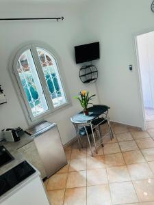 Un comedor con una mesa y una ventana. en Studio l'olivier, en Grasse