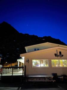 a building with lights in the windows at night at Kaikanten Rorbuer in Sennesvik
