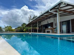 a swimming pool in front of a house at Village des Iles in Praslin