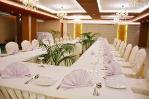 a row of tables with white chairs and napkins at Asia Hotel & Resorts in Dhaka