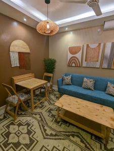 a living room with a blue couch and a table at Serene Furnished Apartments in Vipingo