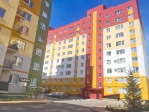 a row of colorful buildings in a parking lot at Апартаменти в ЖК Тріумф in Lutsk