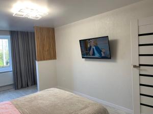 a bedroom with a tv on a wall with a bed at Апартаменти в ЖК Тріумф in Lutsk