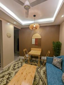 a living room with a table and a blue couch at Serene Furnished Apartments in Vipingo