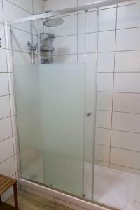 a shower with a glass door in a bathroom at Alfazema Alojamento Local in Angra do Heroísmo