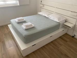 a large bed with two towels on top of it at Alfazema Alojamento Local in Angra do Heroísmo