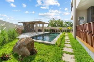 un patio trasero con piscina y cenador en Indian Summer by IHR, en Flic en Flac