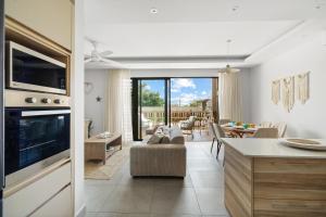 a kitchen and living room with a couch and a table at Indian Summer by IHR in Flic-en-Flac