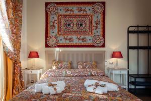 a bedroom with a bed with pillows and a rug on the wall at Le Meraviglie della Sicilia in Palermo
