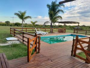 a wooden deck with a swimming pool and a wooden fence at Las Lambertianas in Colonia Elía