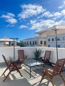 大加那利岛拉斯帕尔马斯Coliving Villa El Gago的一个带椅子和玻璃桌的屋顶庭院