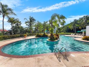 a swimming pool at a resort with palm trees at Rio Mar Village Beach Apt for Families and Groups in Rio Grande