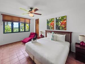 a bedroom with a large white bed and a red chair at Rio Mar Village Beach Apt for Families and Groups in Rio Grande +30 photos