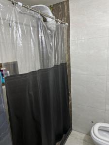 a bathroom with a black shower curtain and a toilet at Casa do love in Salvador