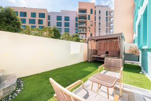 a small backyard with a lawn with chairs and a gazebo at Luxury Huge 1BR apartment With Private Garden in Uptown Al Zahia in Sharjah