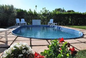 a small pool with chairs and a table and flowers at Villa Vallereale giardino e piscina uso esclusivo in Itri