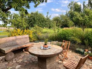 a table and a bench in a garden at Hof Appelbue - Urlaub in zwei Ferienwohnungen im Storchendorf Bergenhusen in Bergenhusen