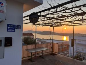 eine Bank auf einem Balkon mit Blick auf den Sonnenuntergang im Hintergrund in der Unterkunft Apartments Sun Rogoznica in Podglavica