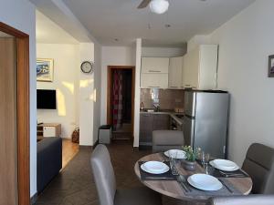 eine Küche und ein Esszimmer mit einem Tisch und einem Kühlschrank in der Unterkunft Apartments Sun Rogoznica in Podglavica + 15 Fotos