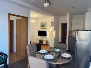 eine Küche und ein Esszimmer mit einem Tisch und Stühlen in der Unterkunft Apartments Sun Rogoznica in Podglavica