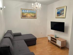 ein Wohnzimmer mit Couch und Flachbildfernseher in der Unterkunft Apartments Sun Rogoznica in Podglavica