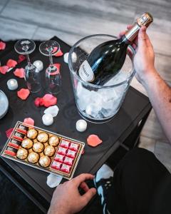 a person pouring a bottle of wine into a table at Au petit bonheur imprévu in Douai