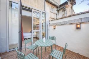 a patio with a table and chairs on a balcony at Villa Victor Hugo by Odomo in Avignon