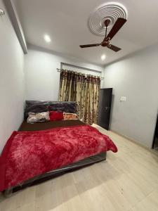 una camera da letto con un letto e un ventilatore a soffitto di The Family Nest a Prayagraj