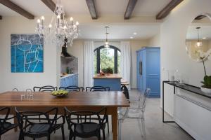 cocina y comedor con armarios azules y mesa de madera en Villa Ovi by IstriaLux, en Karojba