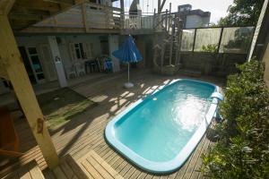 een zwembad op een terras met parasol bij OzeanHaus, Praia do Sol in Barra Velha