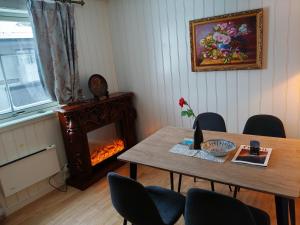 a dining room with a table and a fire place at Trysil sentrum leilighet in Trysil