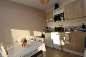 a kitchen with a white table and a white refrigerator at Le Dream by Tranquil at Home - Parking, Piscine, Plage et Wifi in Pornichet