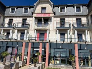 a building with pink columns in front of it at Le Dream by Tranquil at Home - Parking, Piscine, Plage et Wifi in Pornichet