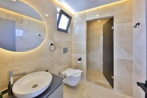 ein Badezimmer mit Waschbecken, Toilette und Spiegel in der Unterkunft 3 Bedroom Luxury Villa, Private Pool, Near Kalkan in Kaş + 24 Fotos